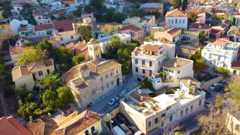 Aerial view of Plaka's red-tiled neoclassical houses and green courtyards