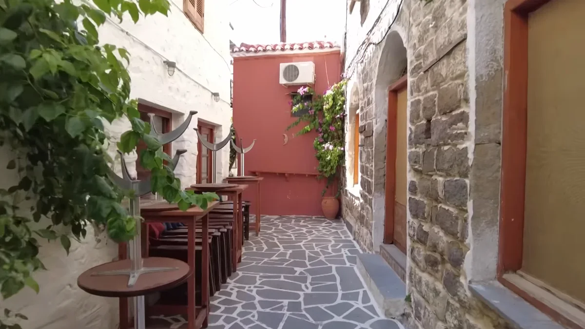 Poros'ta kırmızı cepheli ev ve taş döşeli dar sokak