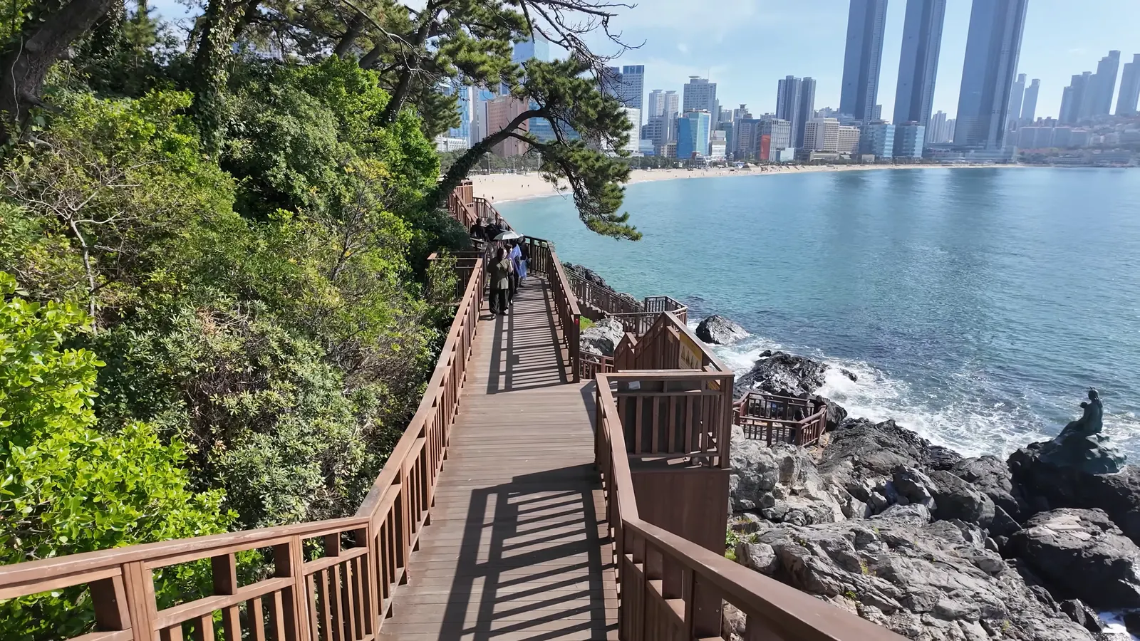 Dongbaek Parkı sahil yürüyüş yolu, arkada Haeundae gökdelenleri, Busan