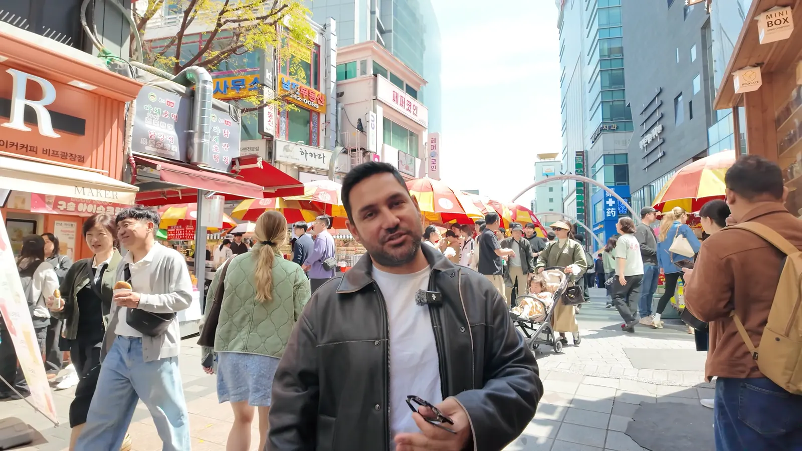 BIFF Meydanı’nda şemsiyeli sokak tezgahları arasında yürüyüş, Busan