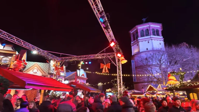 Burgplatz Christmas market in Düsseldorf at night with the lit Schlossturm tower