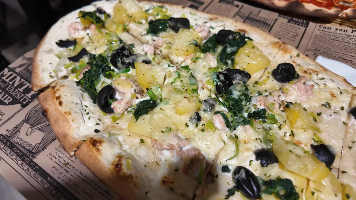 Flammkuchen topped with potato, olives, spinach and tuna