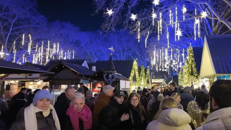 Star lights in the trees and wooden huts at the Markt der Engel Christmas market on Neumarkt, Cologne