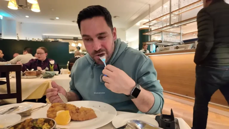 Halil tasting Wiener Schnitzel in Plachutta's busy dining room