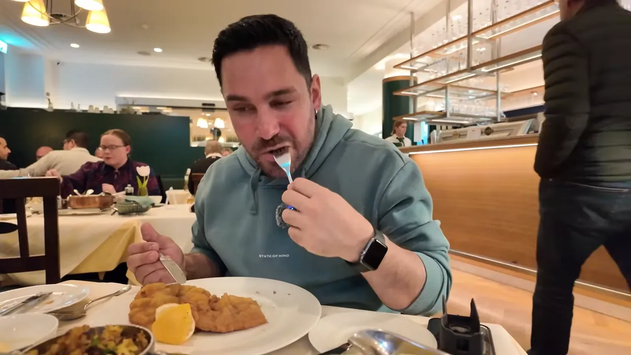 Halil tasting Wiener Schnitzel in Plachutta's busy dining room