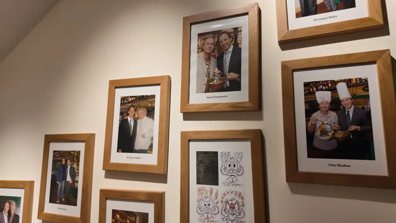Wall of framed photos of famous guests inside Plachutta Wollzeile