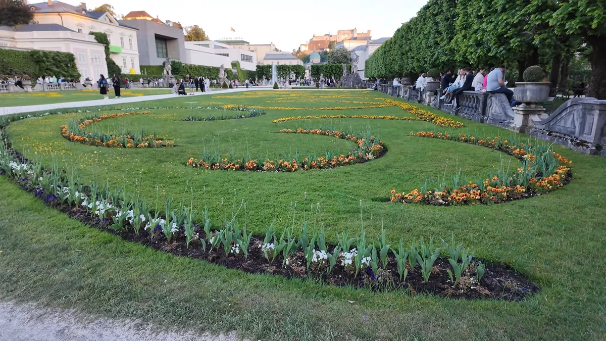 Salzburg Mirabell Bahçesi'nin çiçek tırhları, arkada Mirabell Sarayı