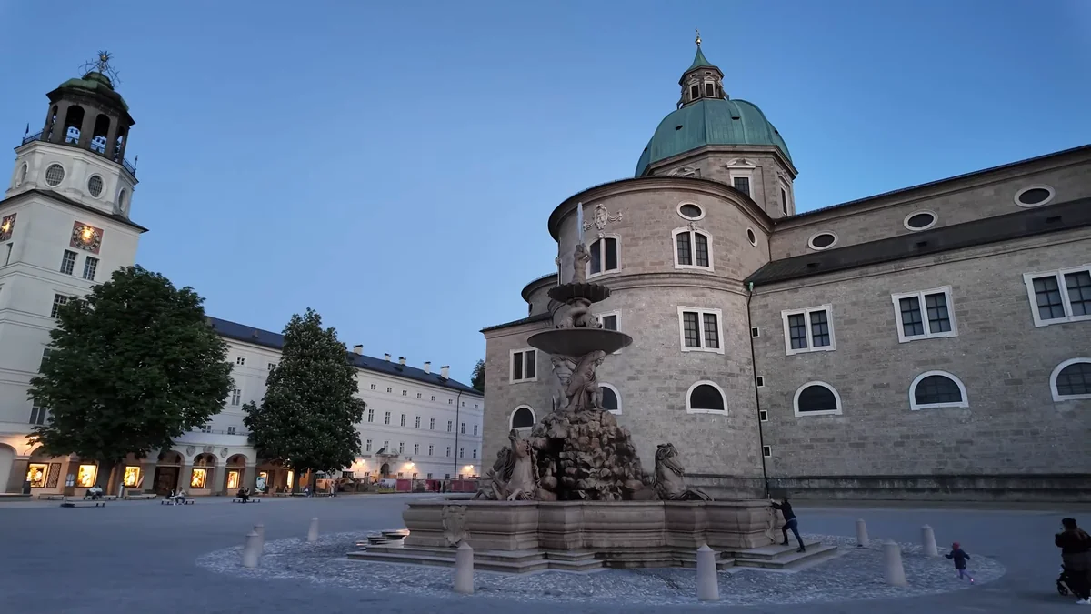 Salzburg Residenzplatz'taki barok çeşme ve katedralin kubbesi